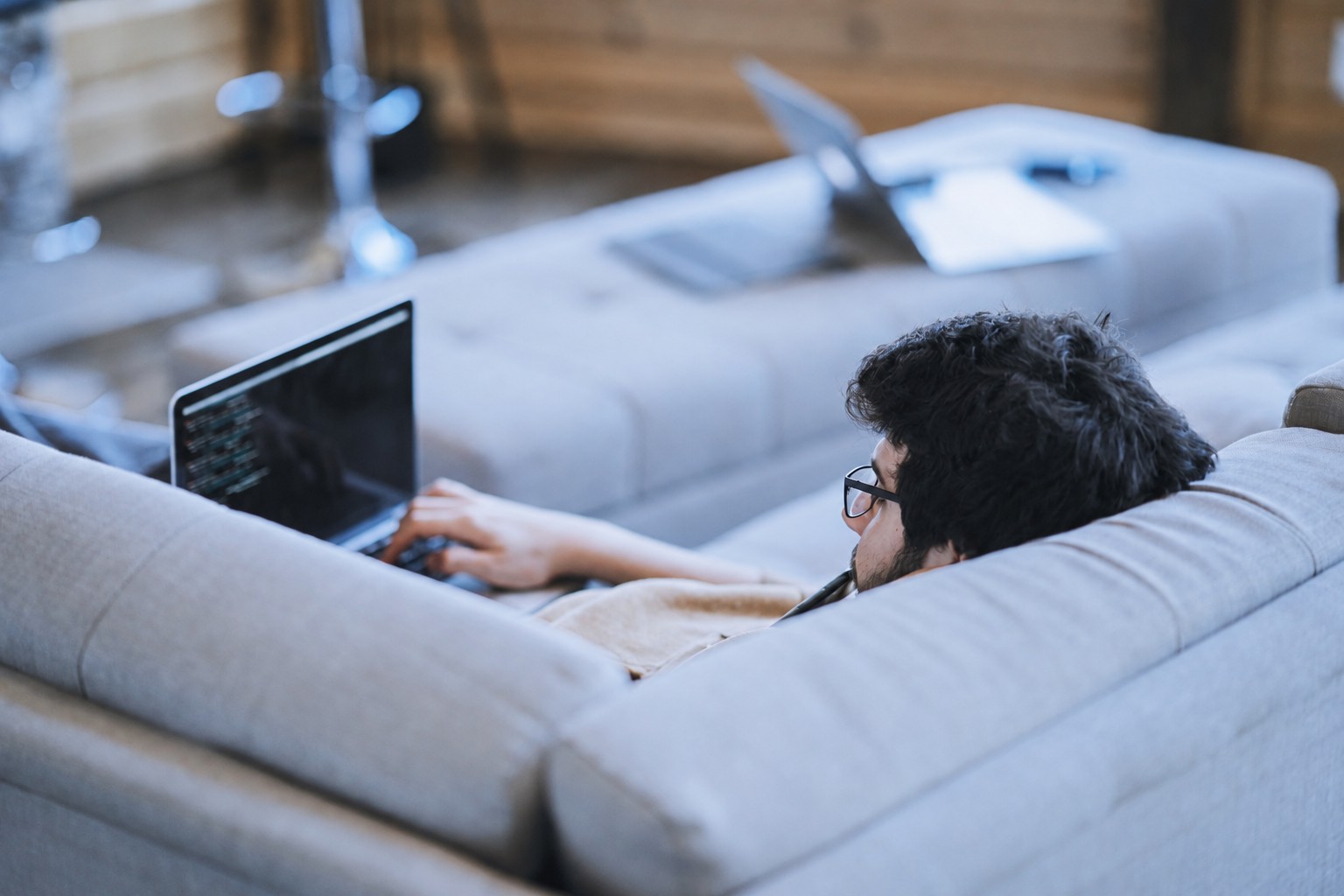 A person browsing the web on a laptop while relaxing at home